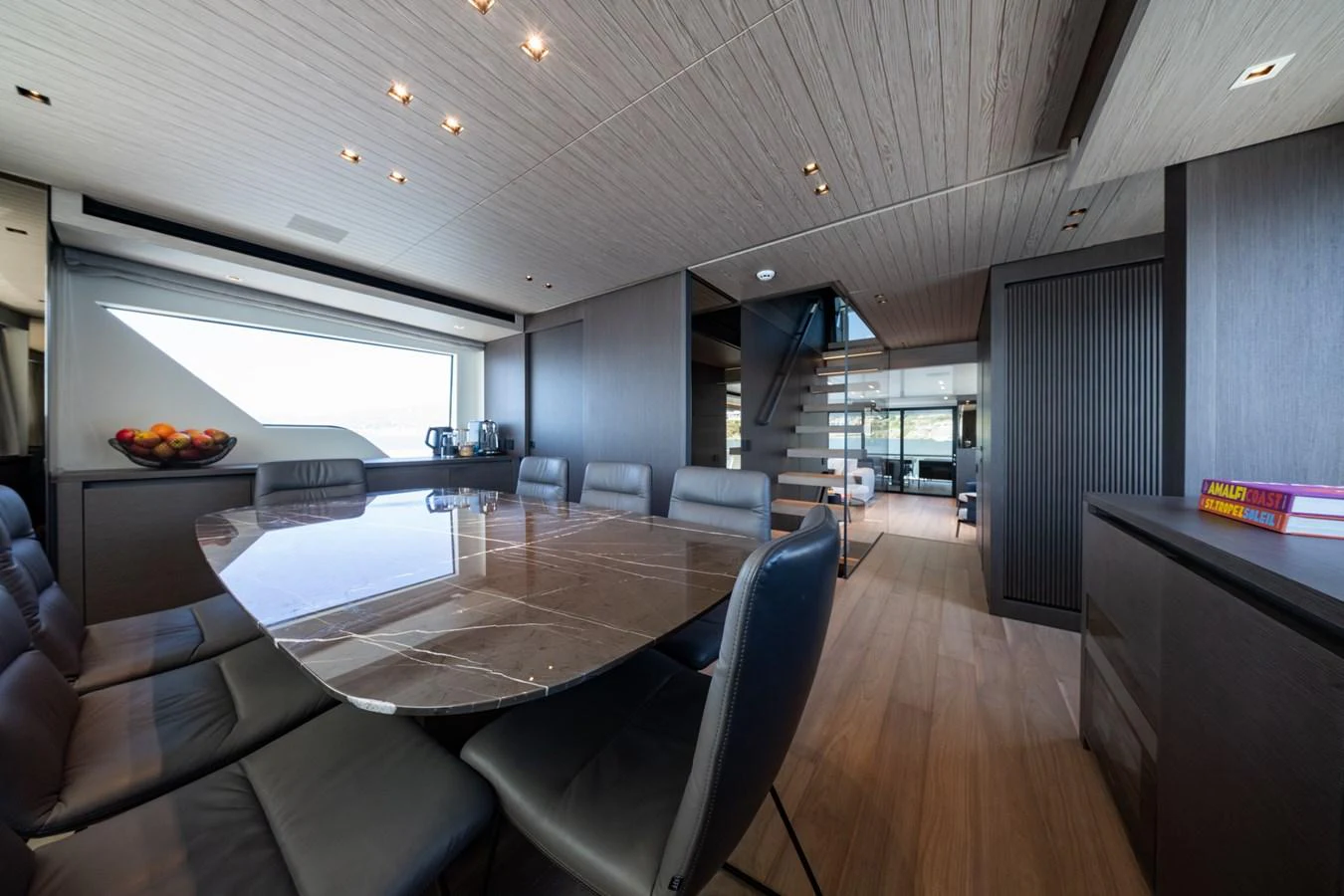 The yacht's dining area features a sleek, modern design with a large table and ample seating. aboard JUNIOR Yacht for Sale