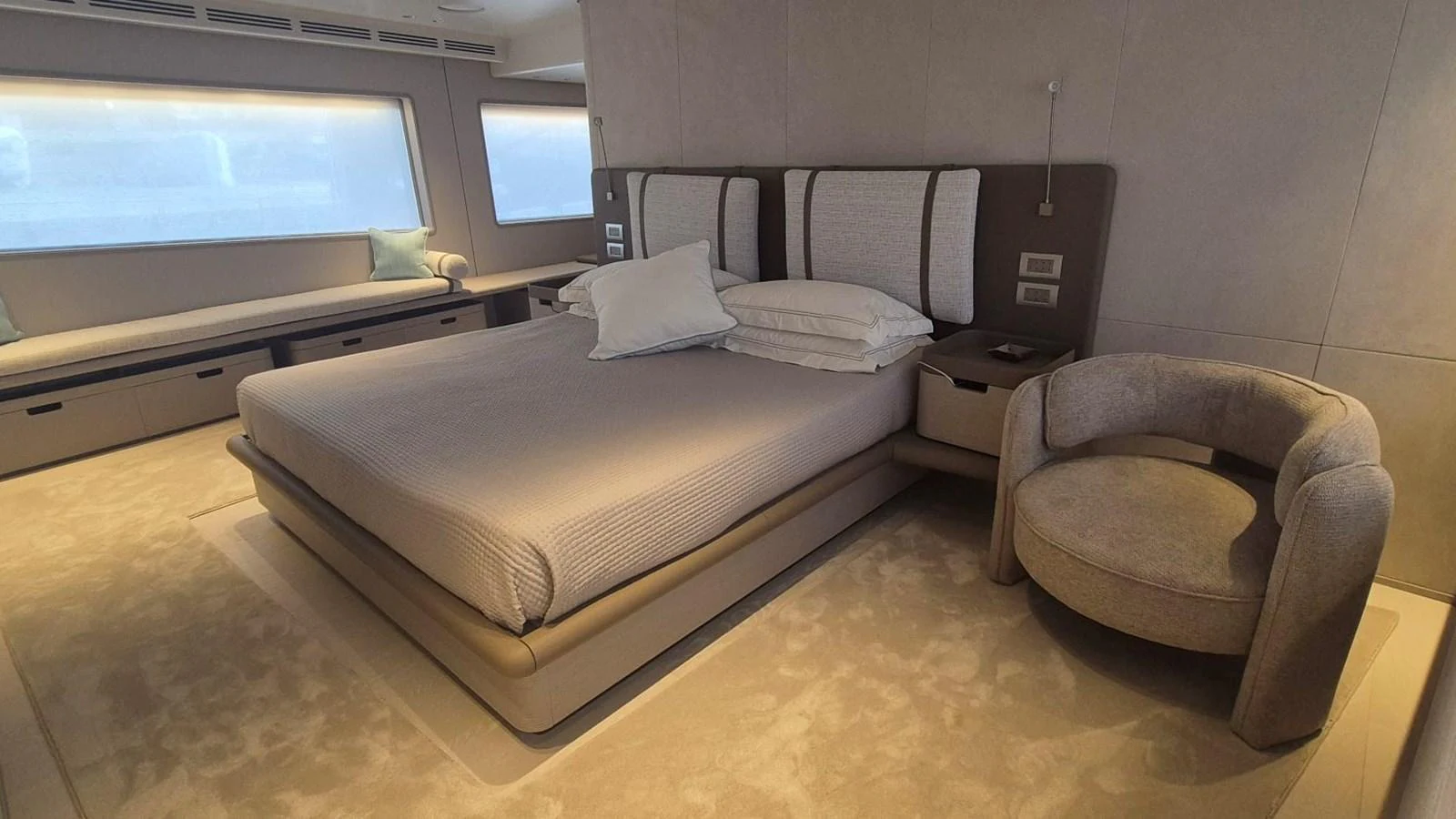 A luxurious stateroom featuring a large bed, plush seating, and ample natural light. aboard SOLE Yacht for Sale