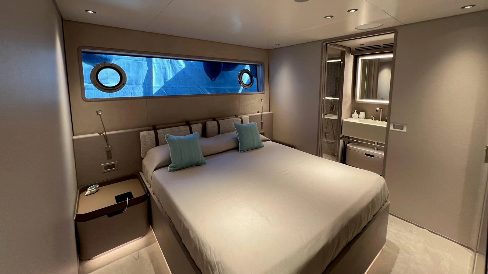 The stateroom features a luxurious bed with modern lighting and an ensuite bathroom. aboard SOLE Yacht for Sale