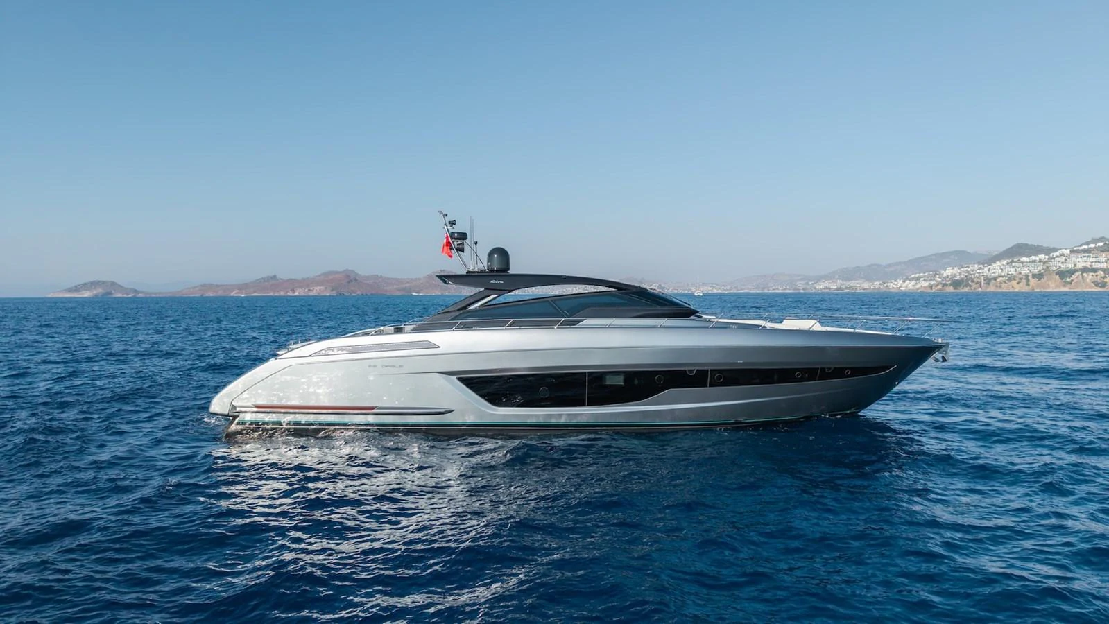 A sleek yacht glides gracefully on the open sea under a clear blue sky. aboard LUCE I Yacht for Sale