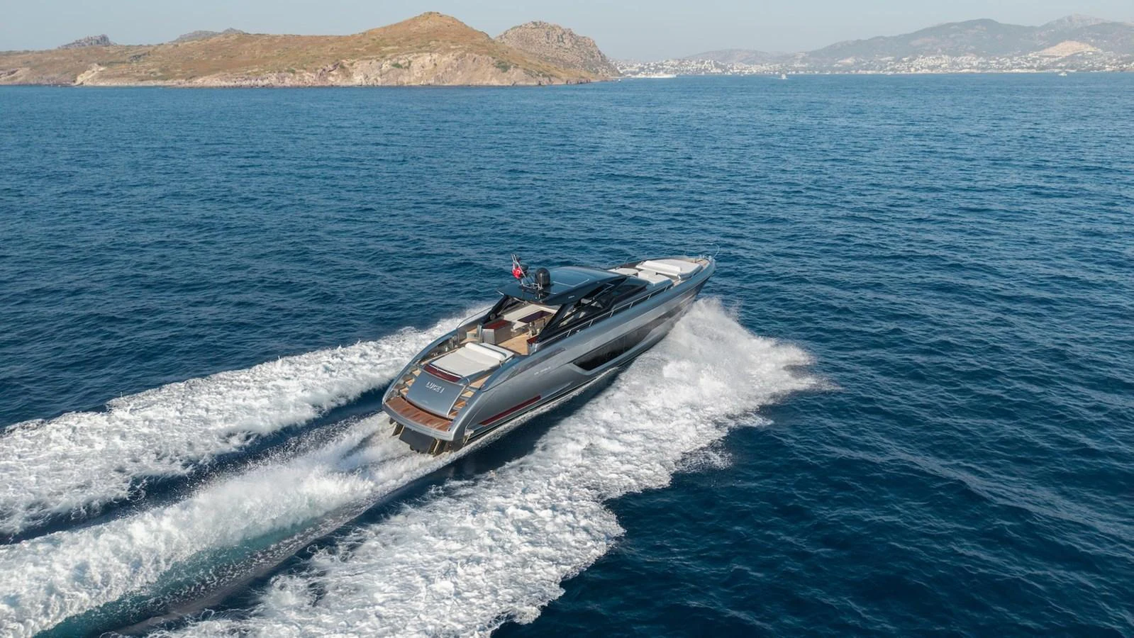 A sleek yacht cruises swiftly across the open sea, leaving a trail of white wake behind. aboard LUCE I Yacht for Sale