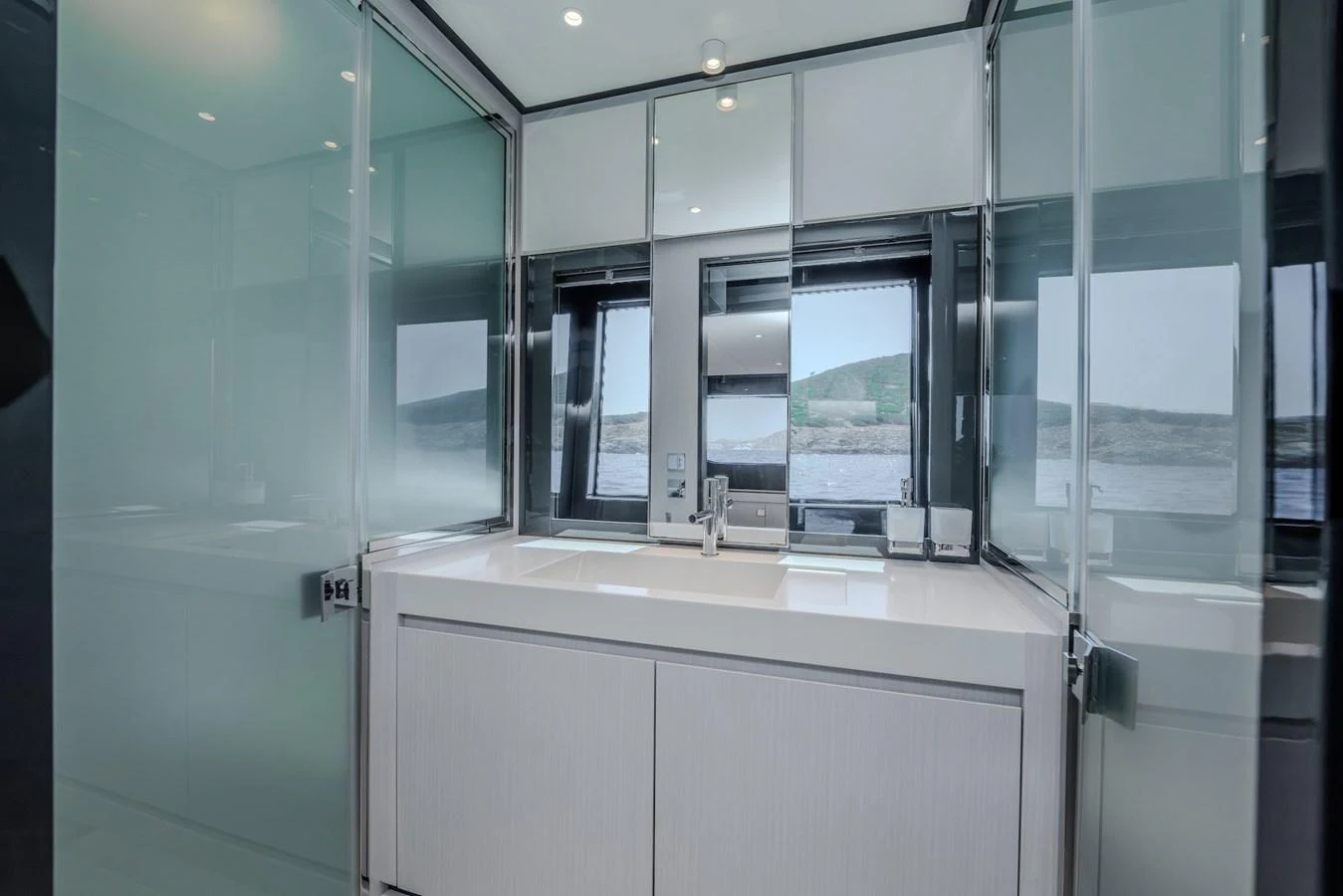 A sleek and modern yacht bathroom with large windows offering a scenic view. aboard LUCE I Yacht for Sale