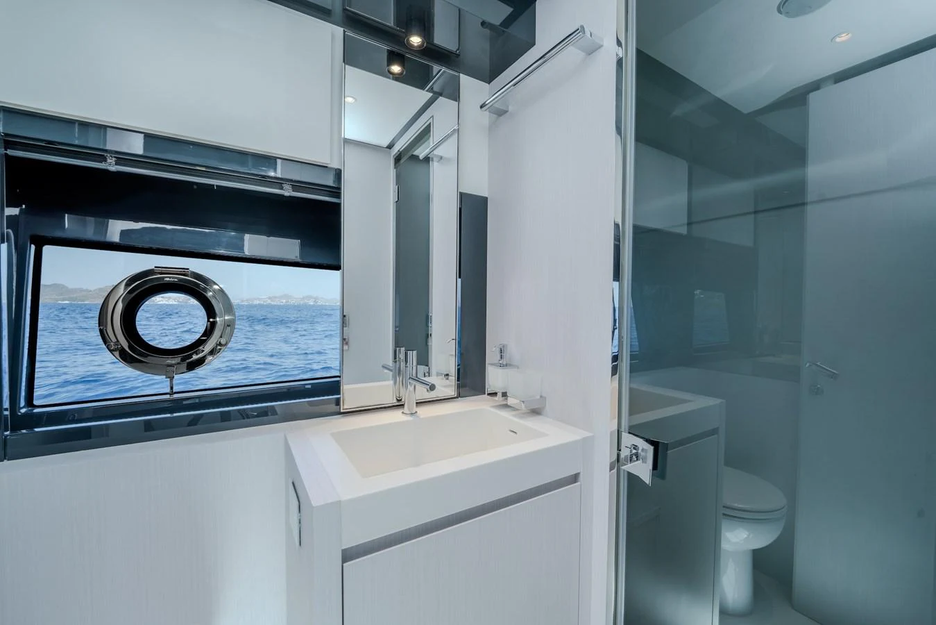 A sleek and modern yacht bathroom with a large window offering a stunning sea view. aboard LUCE I Yacht for Sale