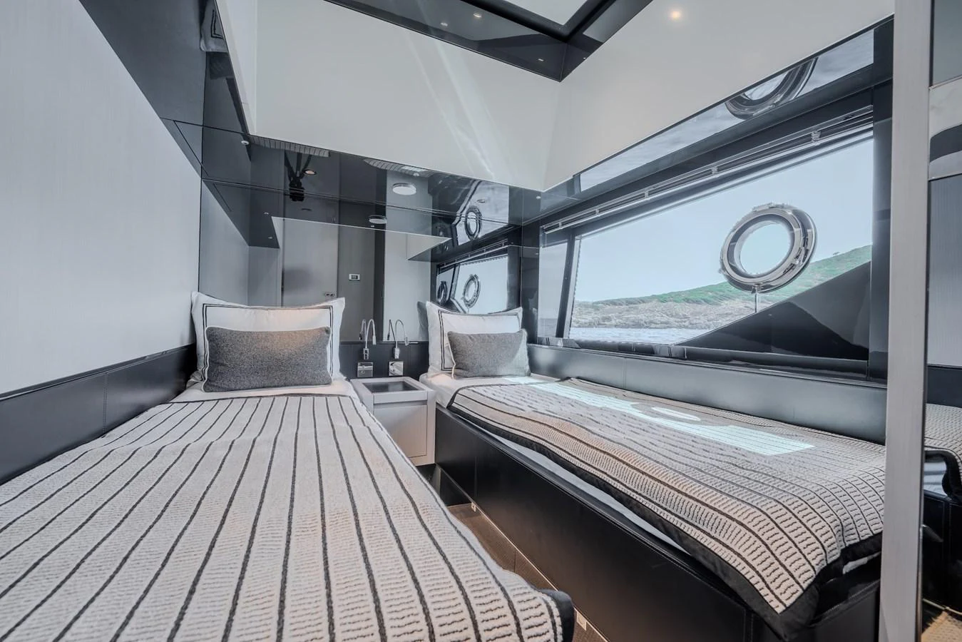 The guest cabin features twin beds with modern decor and large windows offering scenic views. aboard LUCE I Yacht for Sale