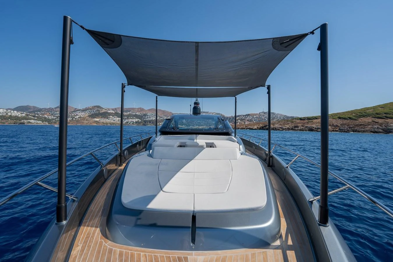 The yacht's foredeck features a spacious sunbathing area with a retractable shade, offering stunning views of the surrounding waters. aboard LUCE I Yacht for Sale