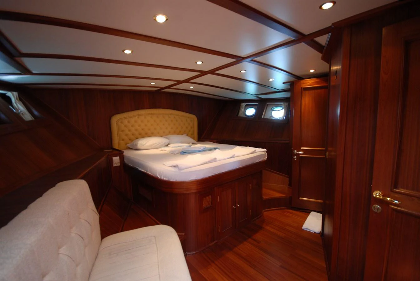 The stateroom features rich wood paneling and a comfortable bed, creating a warm and inviting atmosphere. aboard ARINNA Yacht for Sale