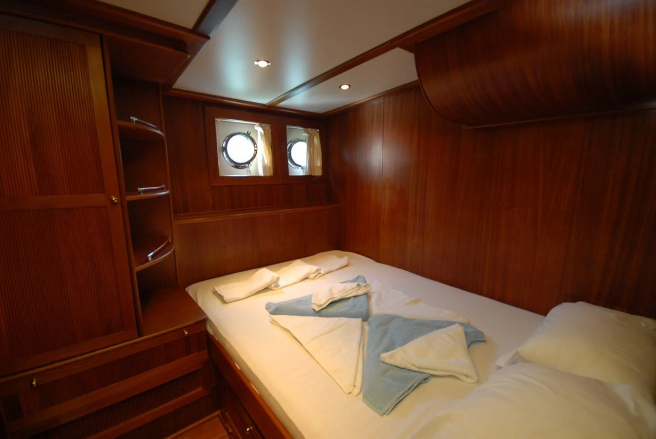 This cozy stateroom features rich wood paneling and soft lighting for a warm, inviting atmosphere. aboard ARINNA Yacht for Sale
