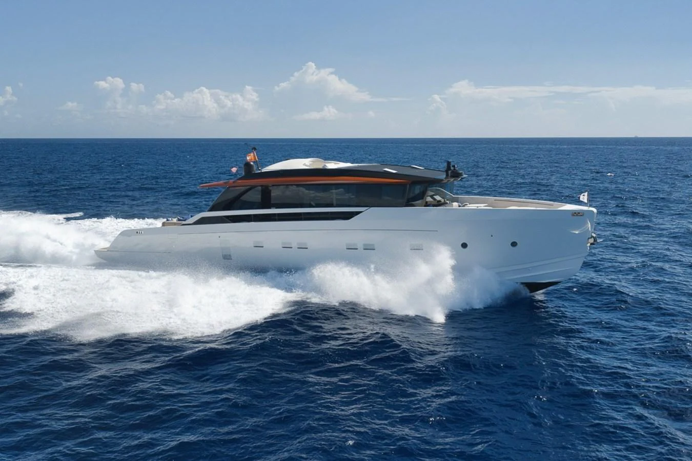 A sleek and modern yacht cruises swiftly through the open sea under a clear blue sky. aboard LAUREN MARIE Yacht for Sale