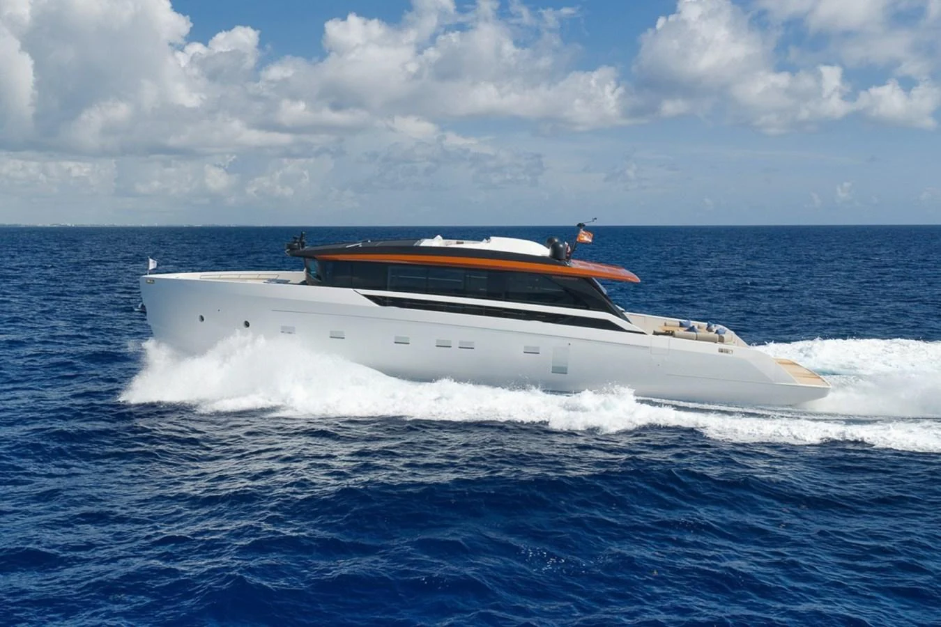 A sleek and modern yacht cruises swiftly through the open sea under a bright blue sky. aboard LAUREN MARIE Yacht for Sale