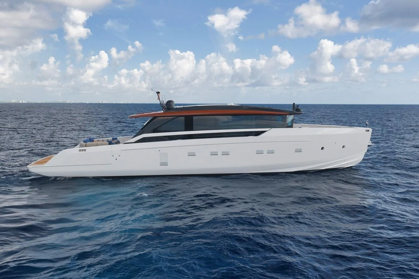 A sleek and modern yacht glides gracefully on the open sea under a partly cloudy sky. aboard LAUREN MARIE Yacht for Sale