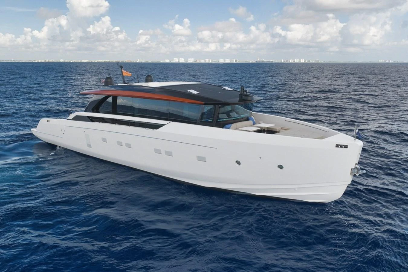A sleek and modern yacht cruising on the open sea under a partly cloudy sky. aboard LAUREN MARIE Yacht for Sale