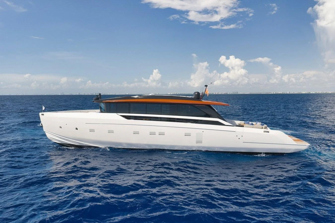 A sleek and modern yacht cruises on the open sea under a clear blue sky. aboard LAUREN MARIE Yacht for Sale