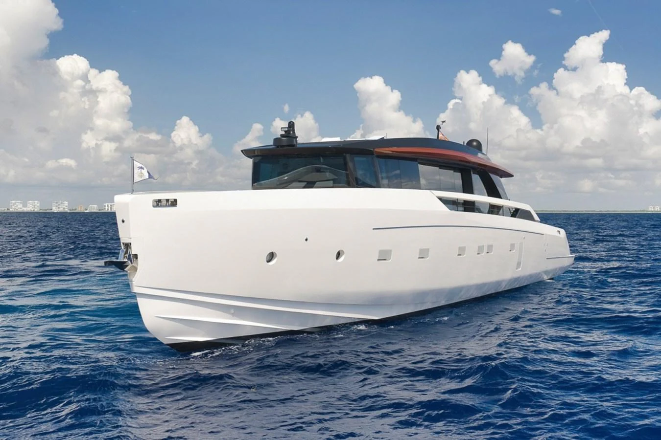 A sleek, modern yacht glides gracefully on the open sea under a bright, blue sky. aboard LAUREN MARIE Yacht for Sale