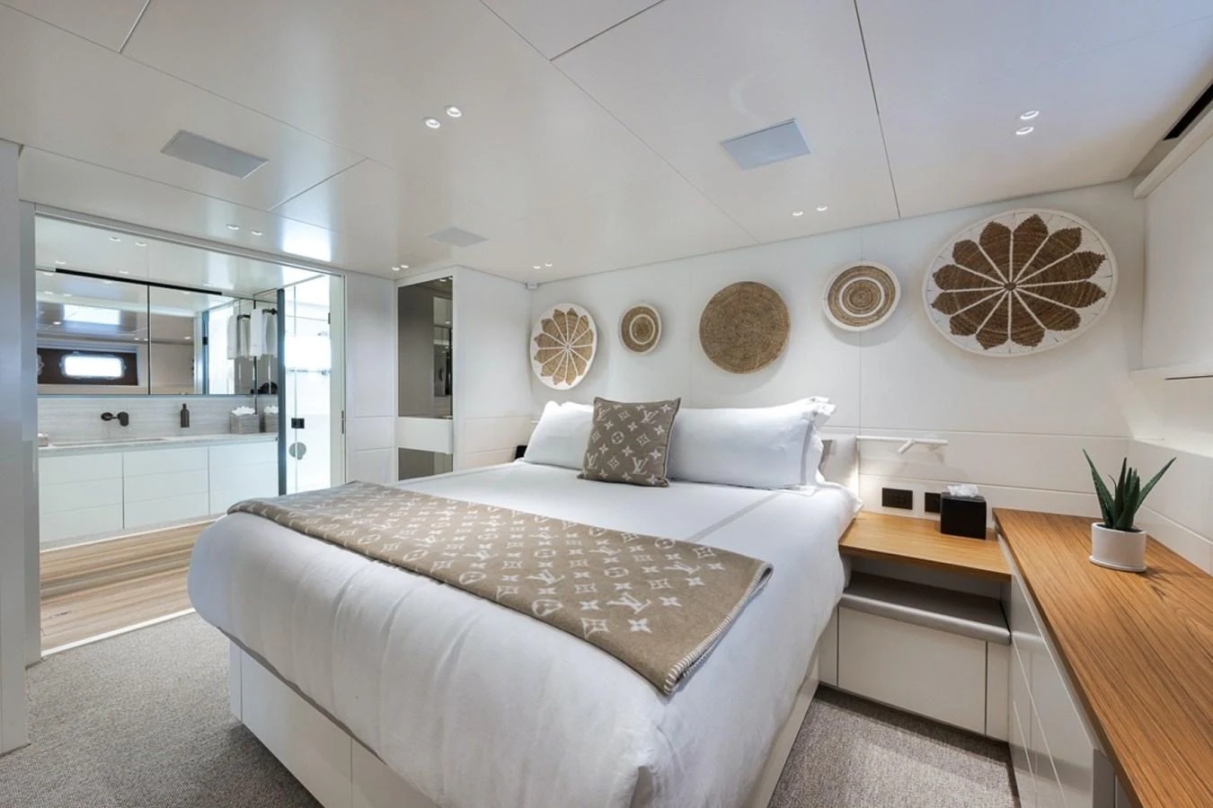 The stateroom features a plush bed with elegant decor and a view into the ensuite bathroom. aboard LAUREN MARIE Yacht for Sale