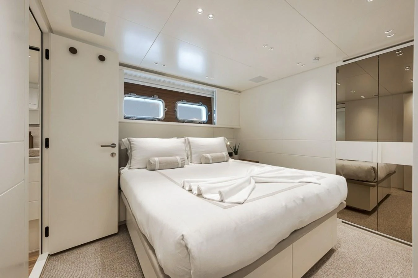 The stateroom features a plush double bed with modern, minimalist decor and ample natural light. aboard LAUREN MARIE Yacht for Sale