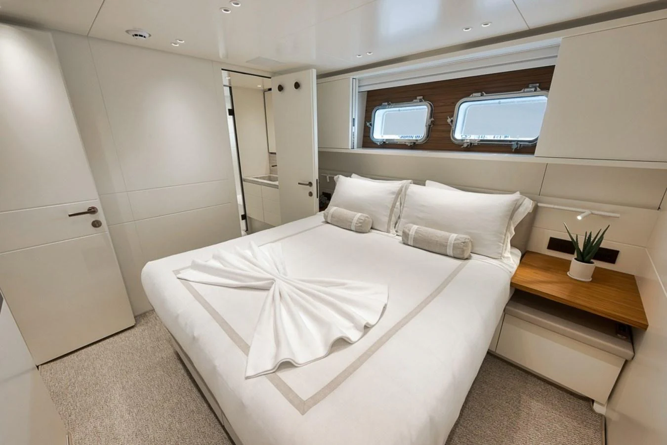 A cozy stateroom featuring a neatly made bed with elegant linens and modern decor. aboard LAUREN MARIE Yacht for Sale