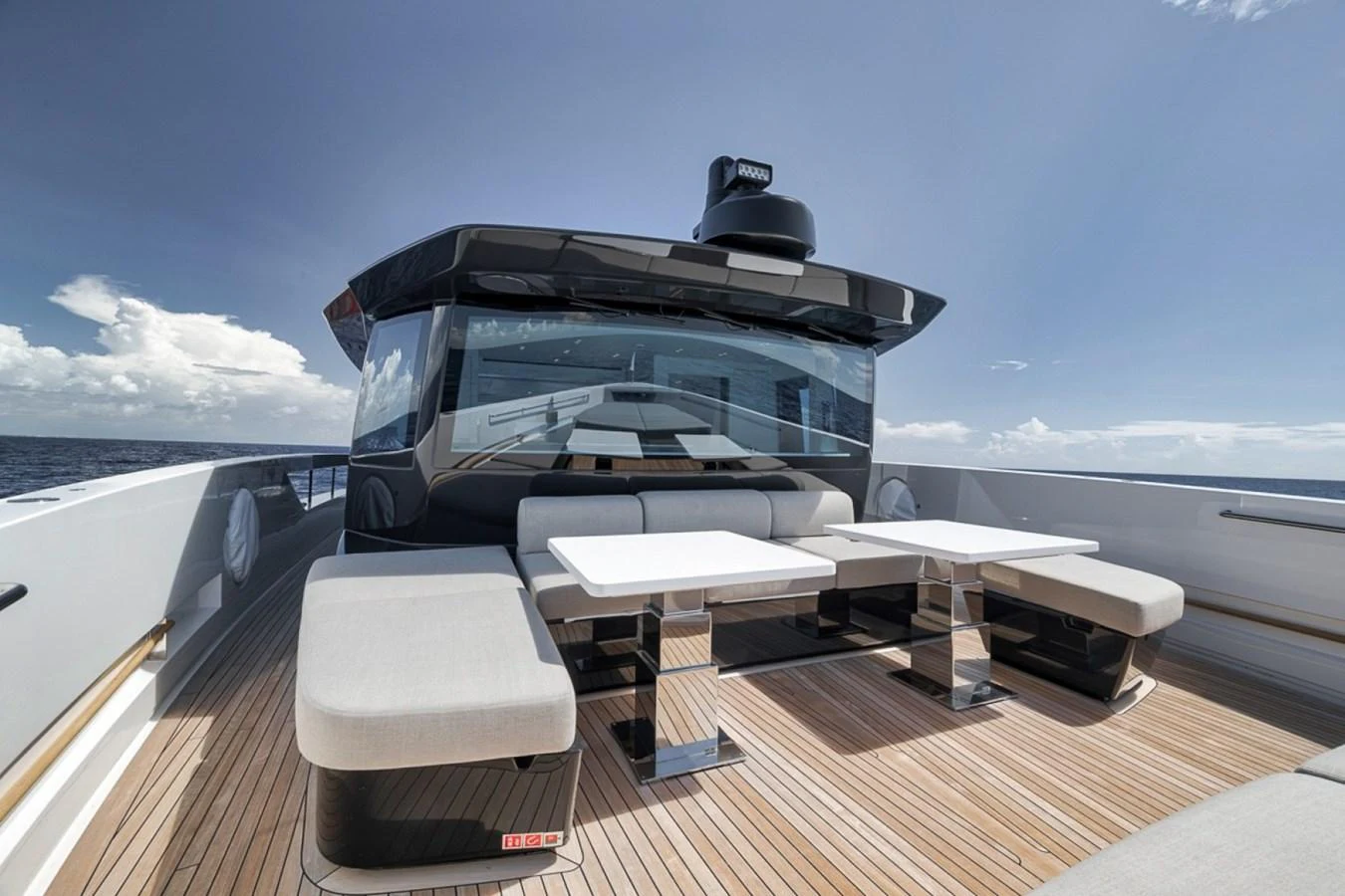 The aft deck features a stylish seating area with modern tables and benches, perfect for outdoor relaxation. aboard LAUREN MARIE Yacht for Sale