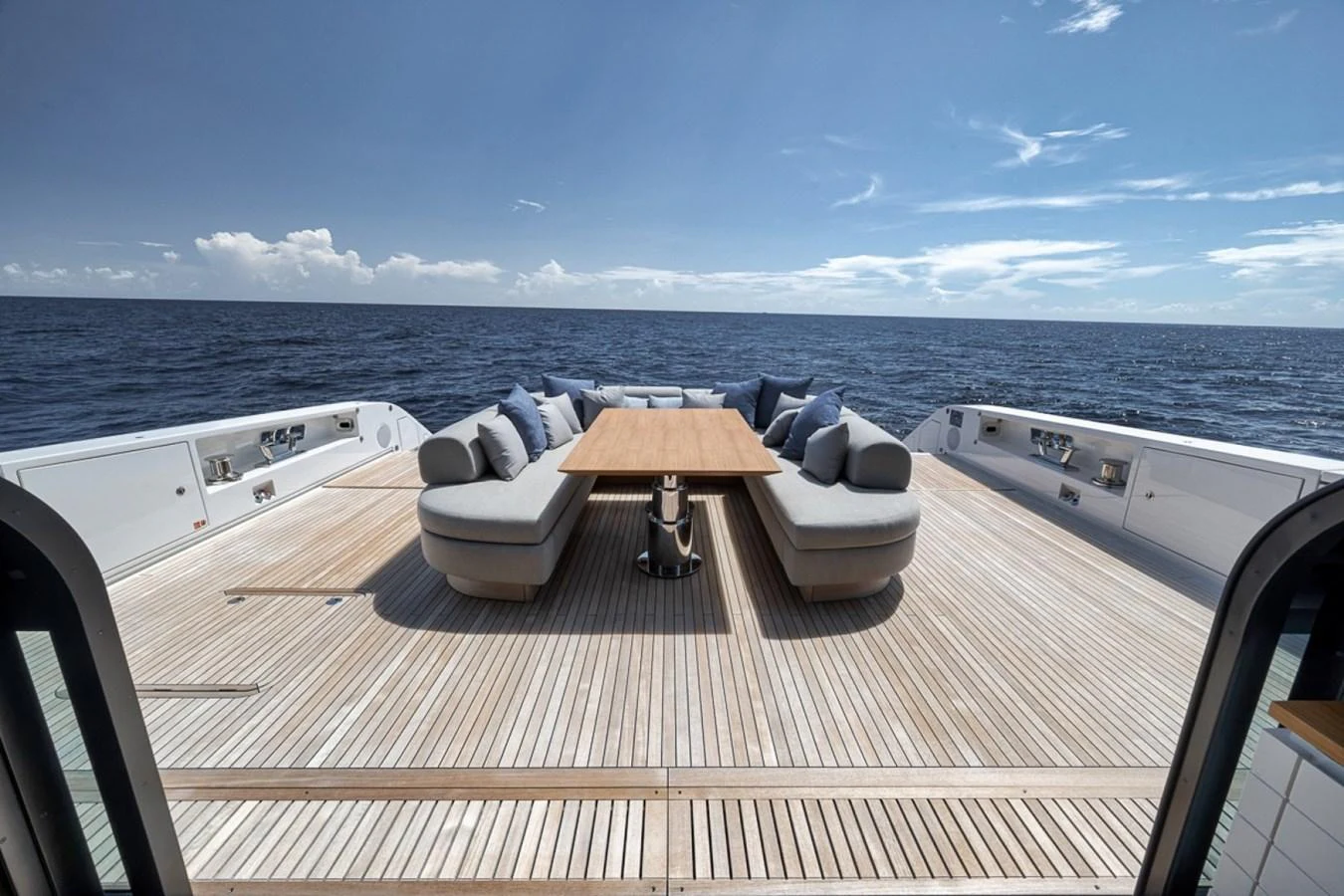 The aft deck features a spacious seating area with a central wooden table, perfect for outdoor relaxation and dining. aboard LAUREN MARIE Yacht for Sale