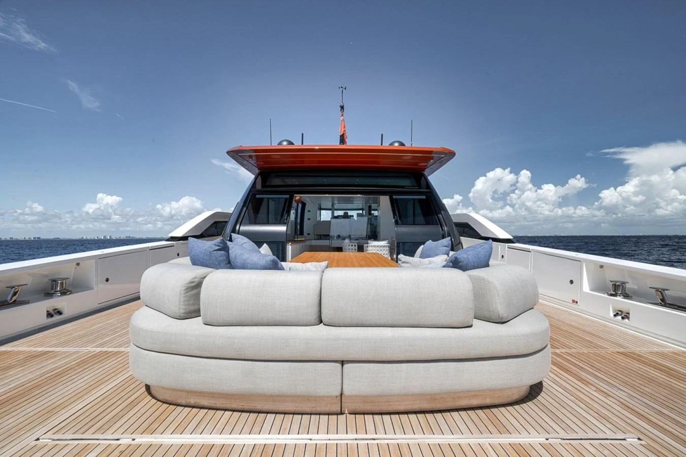 The aft deck features a spacious seating area with plush cushions and a wooden table, perfect for relaxation and socializing. aboard LAUREN MARIE Yacht for Sale