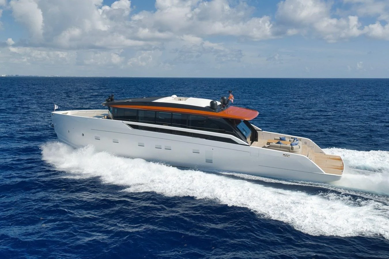 A sleek, modern yacht cruises swiftly through the open sea under a bright blue sky. aboard LAUREN MARIE Yacht for Sale