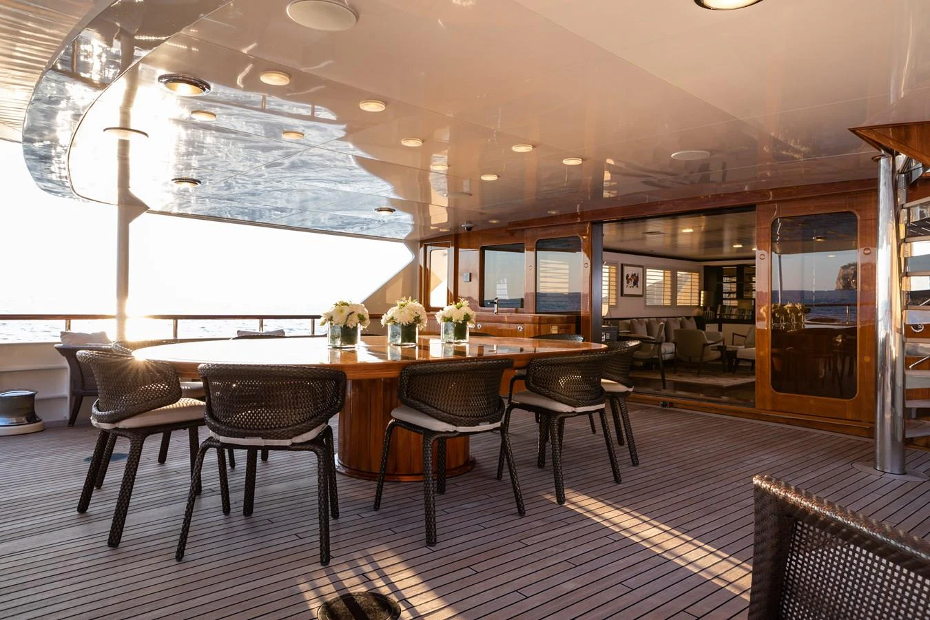 The aft deck features a spacious dining area with elegant furnishings and a beautiful view of the sea. aboard MIRAGE Yacht for Sale