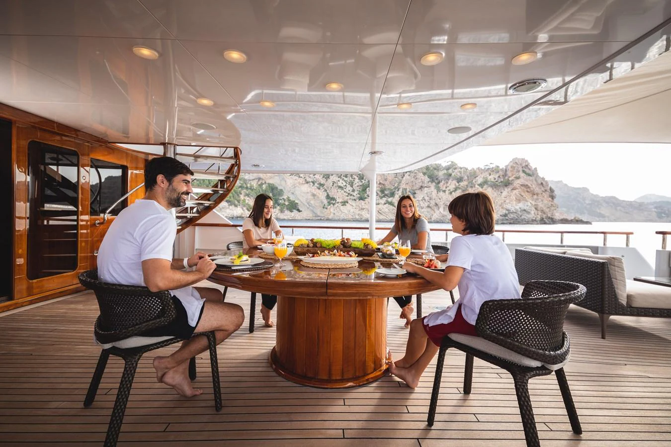 Guests enjoy a meal on the aft deck, surrounded by stunning views. aboard MIRAGE Yacht for Sale
