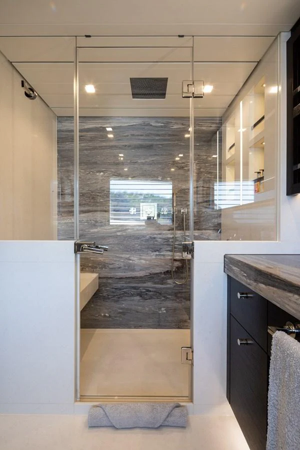 The yacht's bathroom features a sleek design with modern fixtures and a spacious shower area. aboard MIRAGE Yacht for Sale
