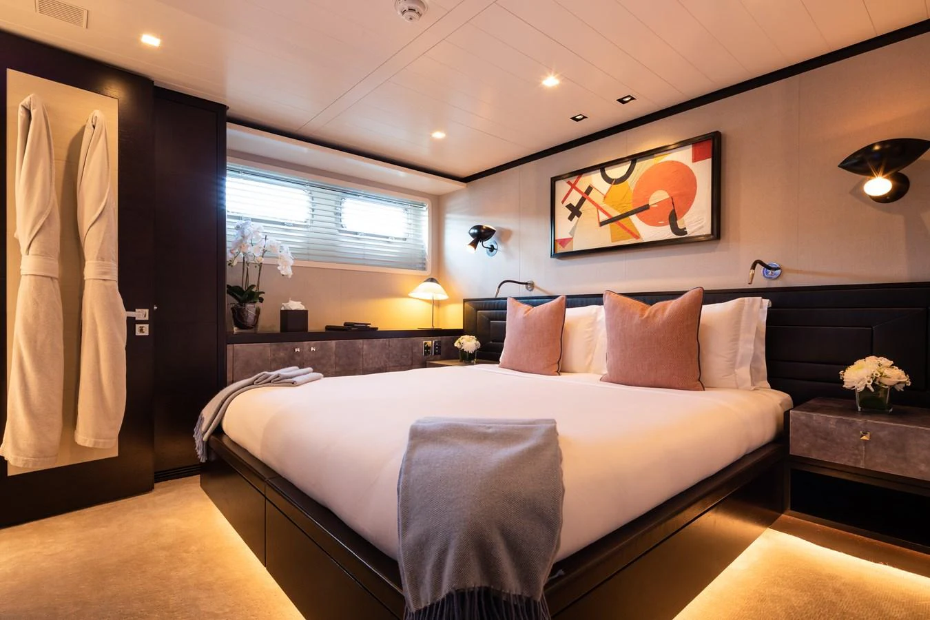 The stateroom features a luxurious bed with elegant decor and ambient lighting. aboard MIRAGE Yacht for Sale