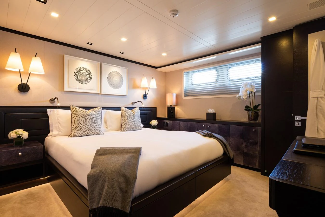 The master stateroom features a luxurious bed with elegant decor and ample lighting. aboard MIRAGE Yacht for Sale
