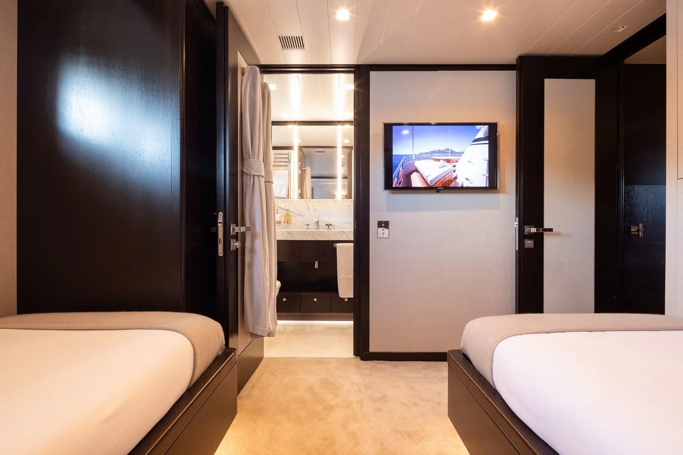 The guest stateroom features twin beds and a view into the ensuite bathroom. aboard MIRAGE Yacht for Sale