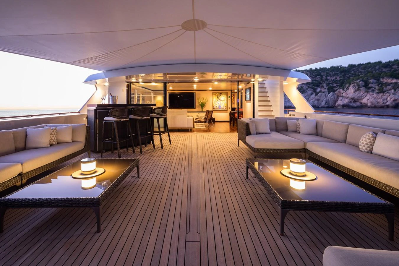 The aft deck features elegant seating areas with a view of the surrounding landscape. aboard MIRAGE Yacht for Sale