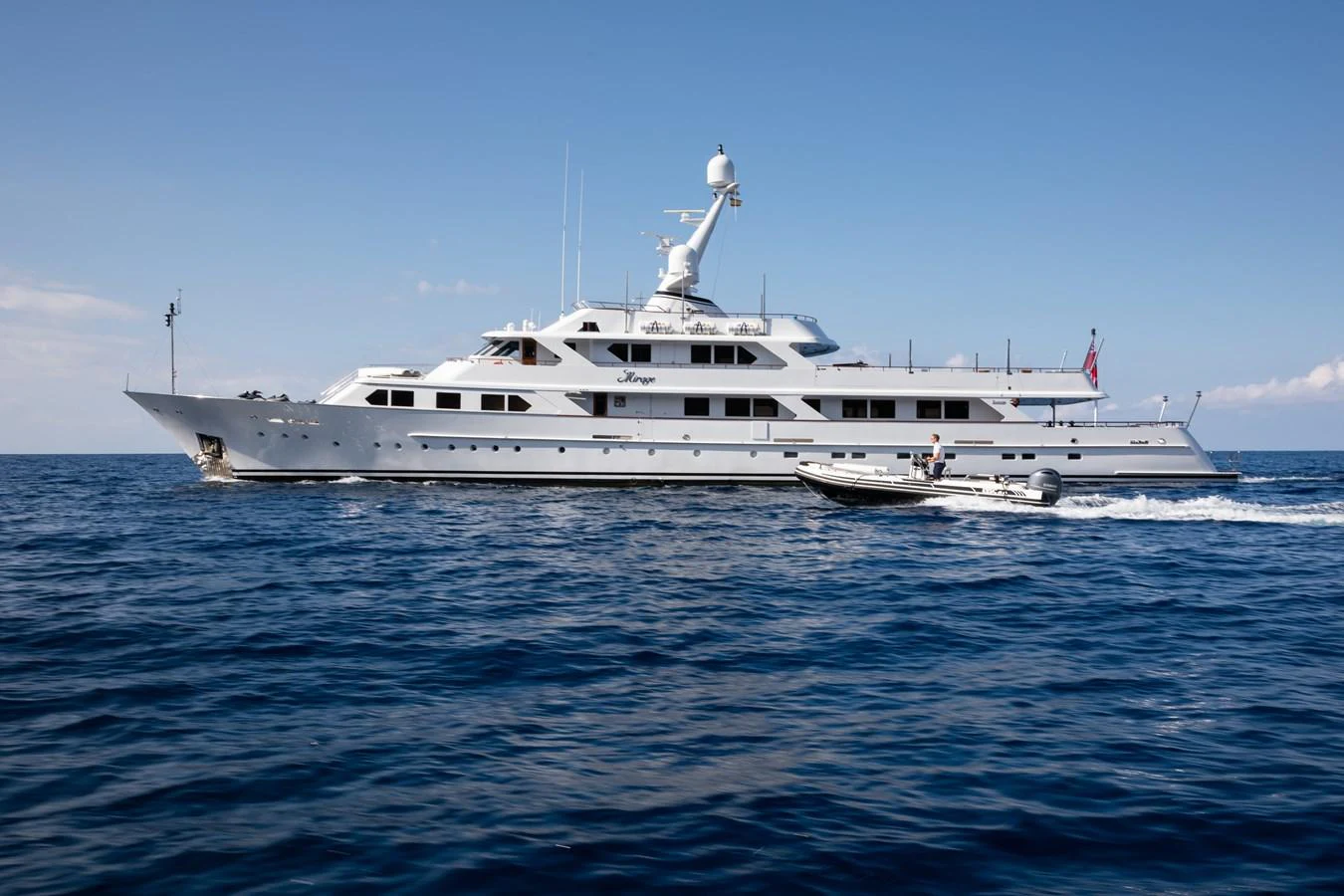 A luxurious yacht cruising on the open sea under a clear sky. aboard MIRAGE Yacht for Sale