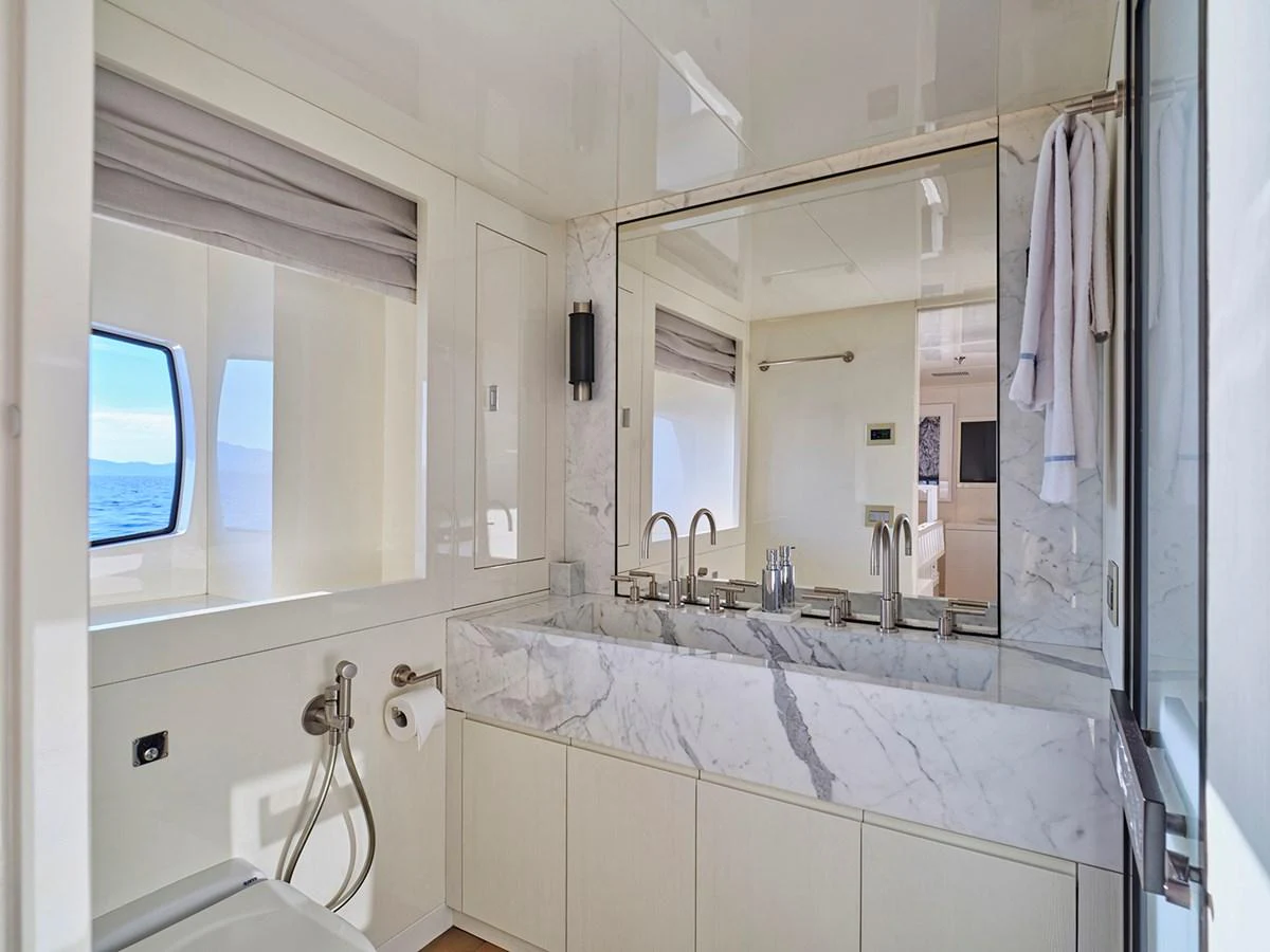 A luxurious yacht bathroom with a marble countertop and modern fixtures. aboard BELITA Yacht for Sale