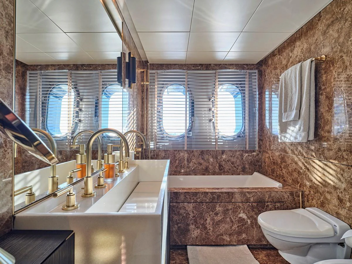 The yacht's bathroom features luxurious marble walls, a spacious bathtub, and elegant fixtures. aboard BELITA Yacht for Sale