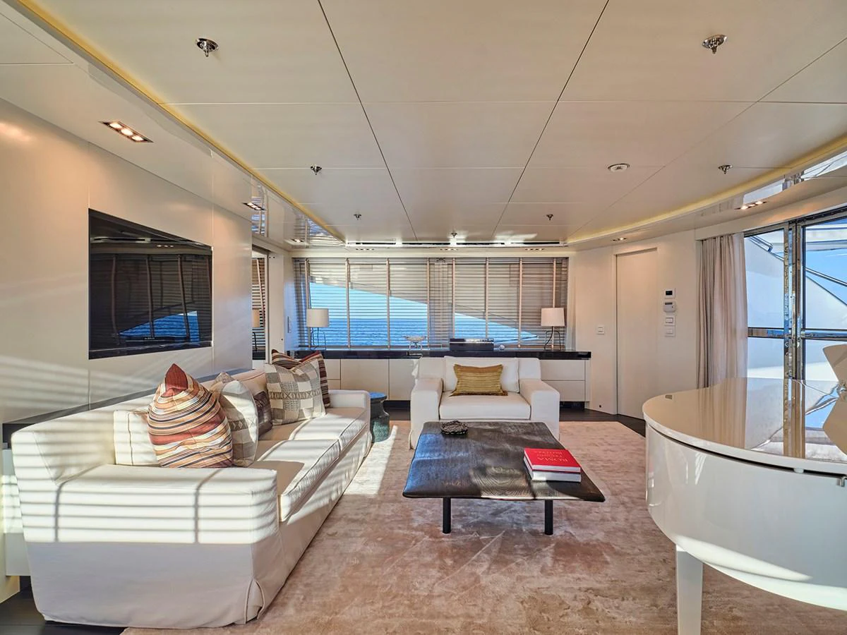 The salon offers a spacious and elegant area with comfortable seating and a grand piano, perfect for relaxation and entertainment. aboard BELITA Yacht for Sale