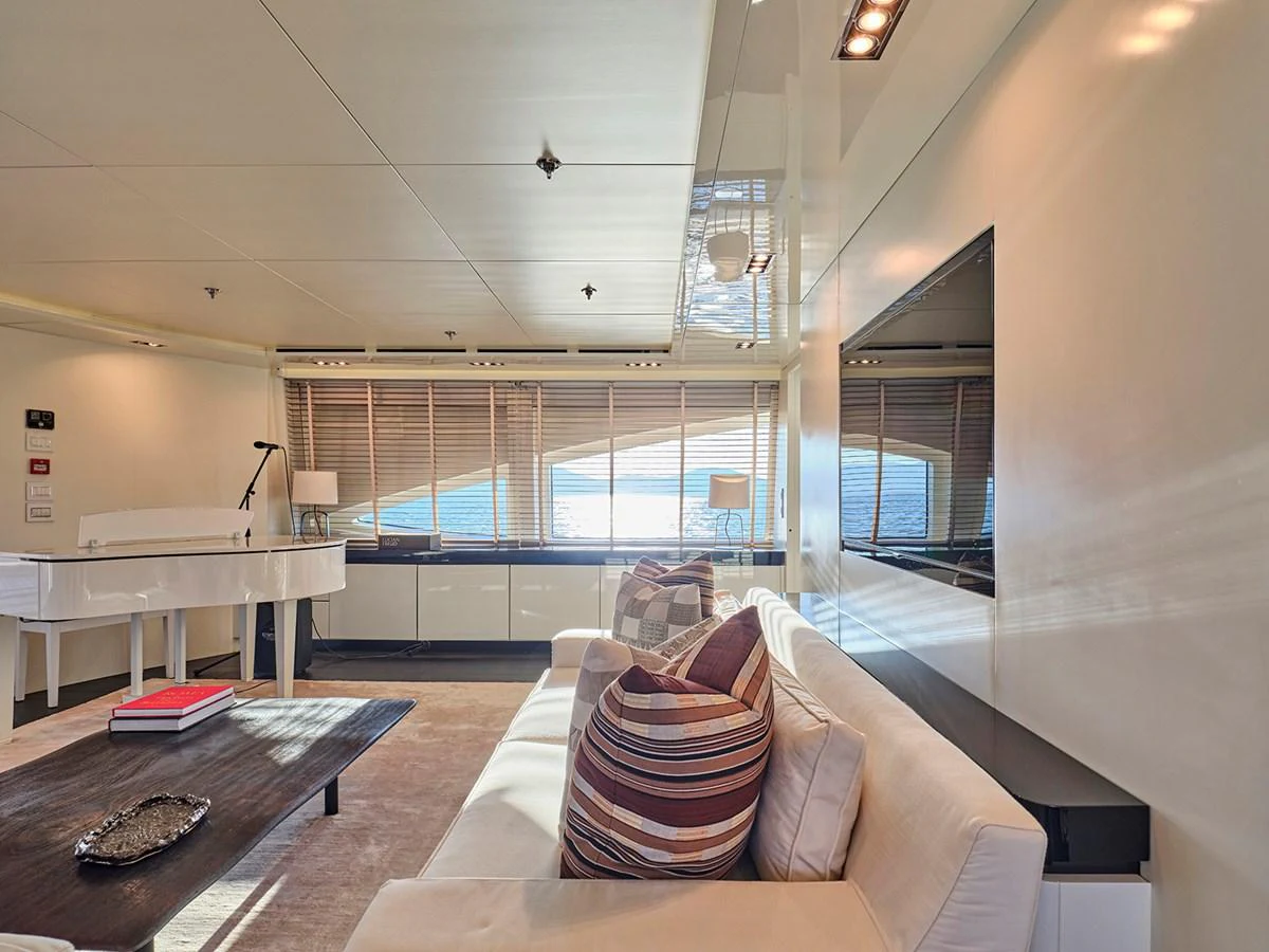 The salon features a comfortable seating area with large windows providing ample natural light and stunning views. aboard BELITA Yacht for Sale