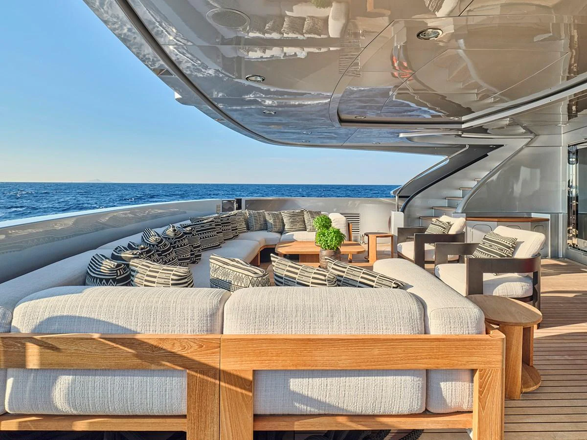The aft deck features a luxurious outdoor seating area with plush cushions and a stunning ocean view. aboard BELITA Yacht for Sale