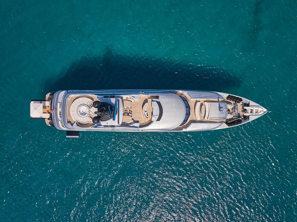 A stunning aerial view of a luxurious yacht cruising on clear blue waters. aboard BELITA Yacht for Sale