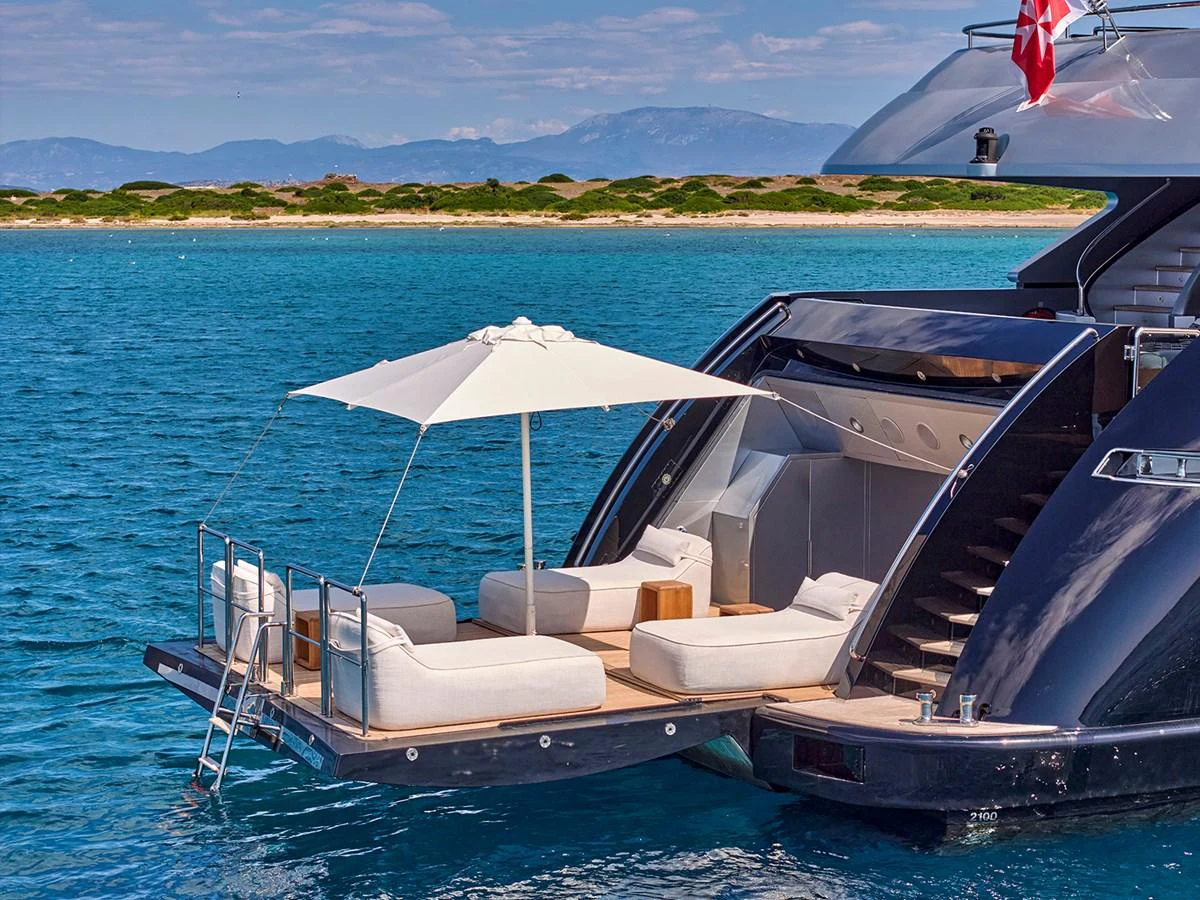 The yacht's aft deck features a luxurious lounging area with comfortable seating and an umbrella, perfect for relaxing by the water. aboard BELITA Yacht for Sale