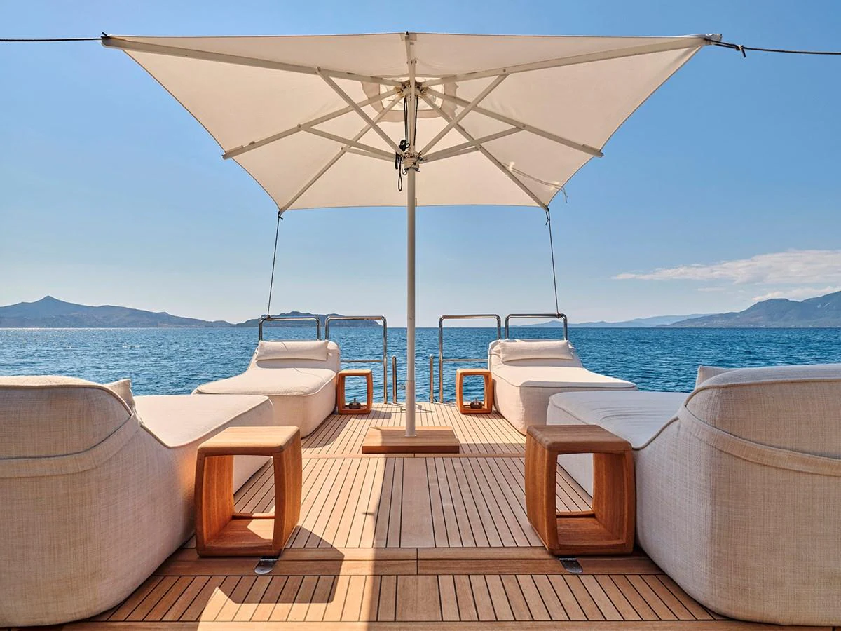 The sundeck offers a serene space with luxurious loungers and a large umbrella, perfect for relaxation. aboard BELITA Yacht for Sale