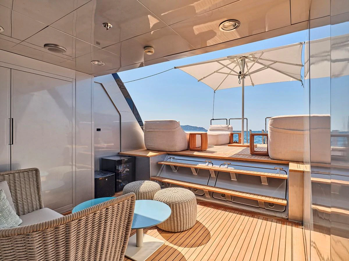 The aft deck offers a luxurious outdoor lounging area with comfortable seating and a stunning view of the sea. aboard BELITA Yacht for Sale