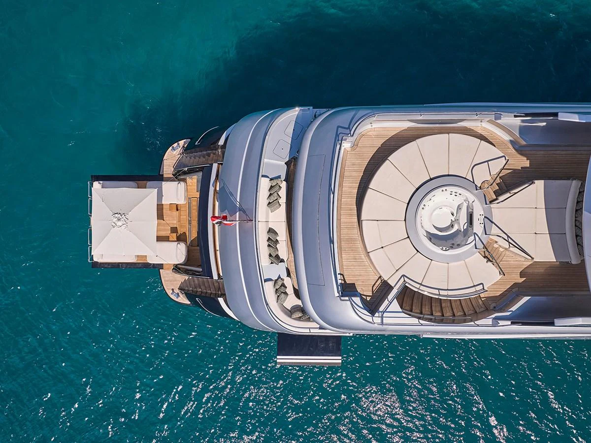 Aerial view of a yacht's sundeck with seating and a jacuzzi, surrounded by clear blue water. aboard BELITA Yacht for Sale