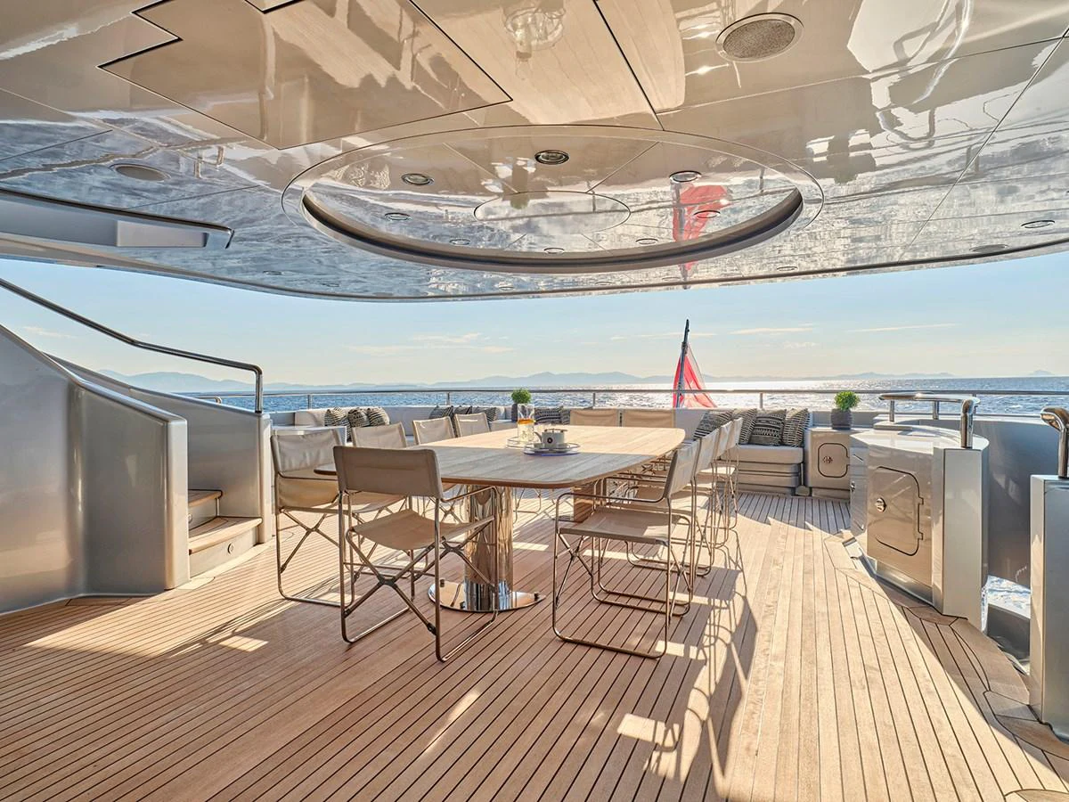 The aft deck features a spacious dining area with elegant seating and stunning ocean views. aboard BELITA Yacht for Sale