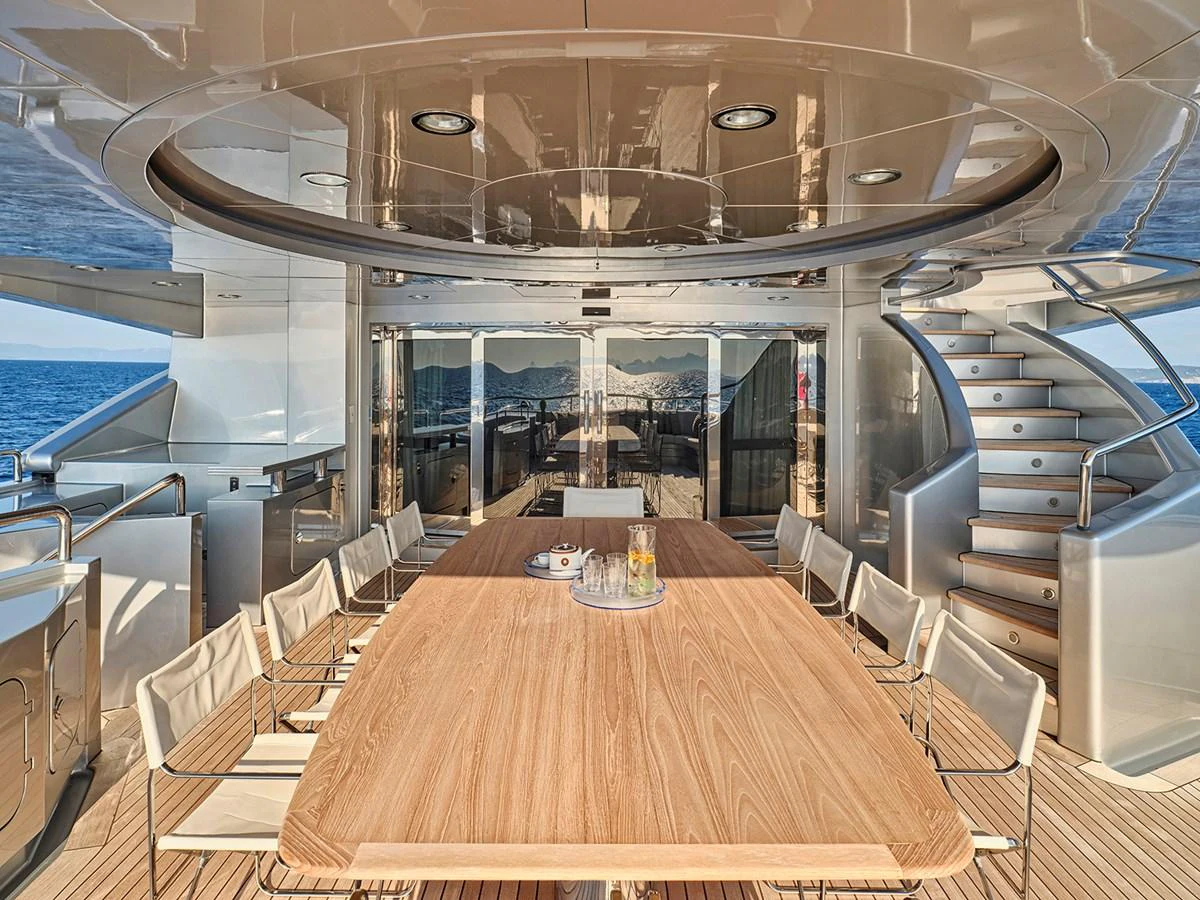 The yacht features a luxurious dining area with a large wooden table and comfortable seating, perfect for enjoying meals with a view of the sea. aboard BELITA Yacht for Sale