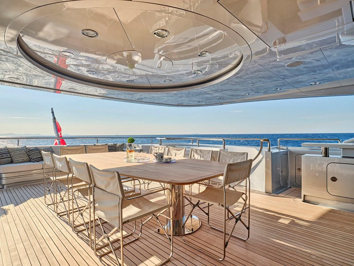 The aft deck features a spacious dining area with a stunning ocean view. aboard BELITA Yacht for Sale