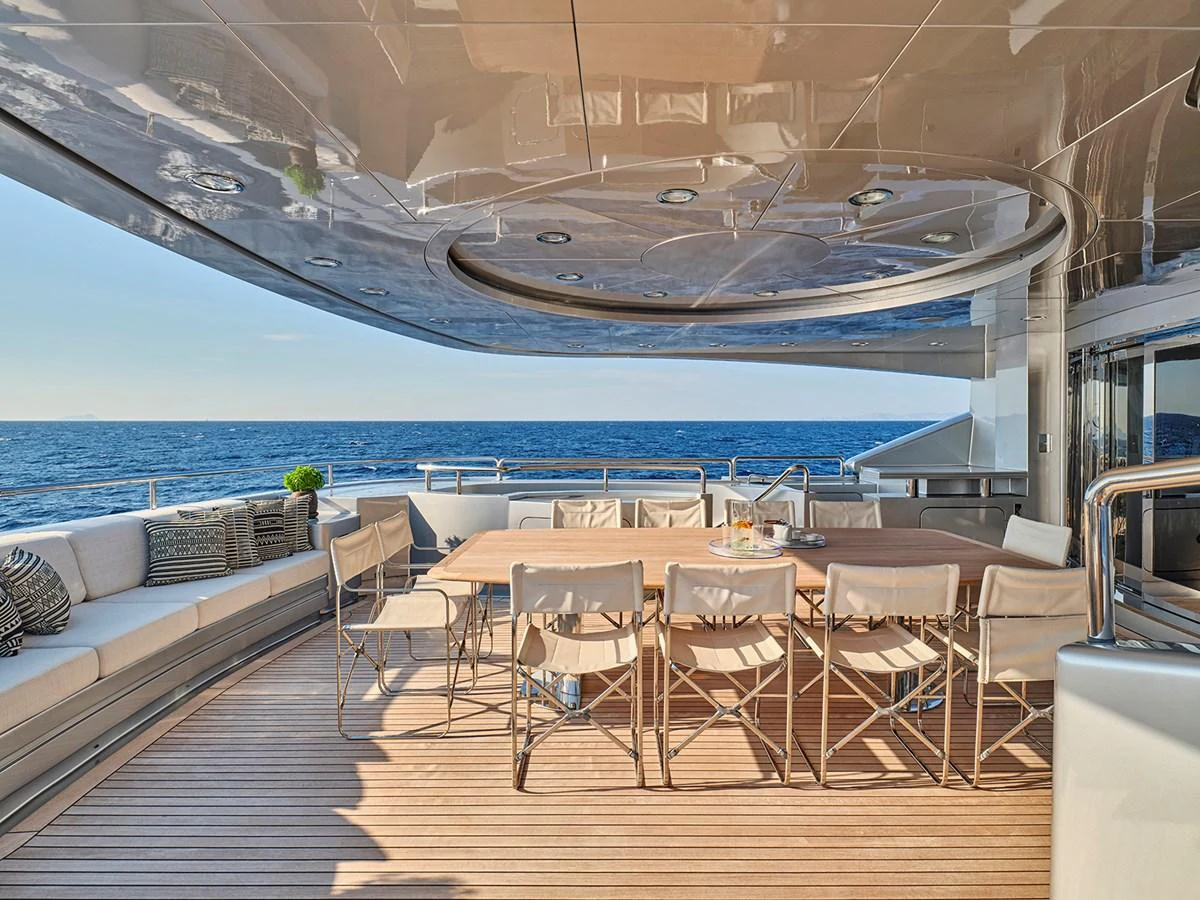 The aft deck offers a luxurious outdoor dining area with stunning ocean views. aboard BELITA Yacht for Sale