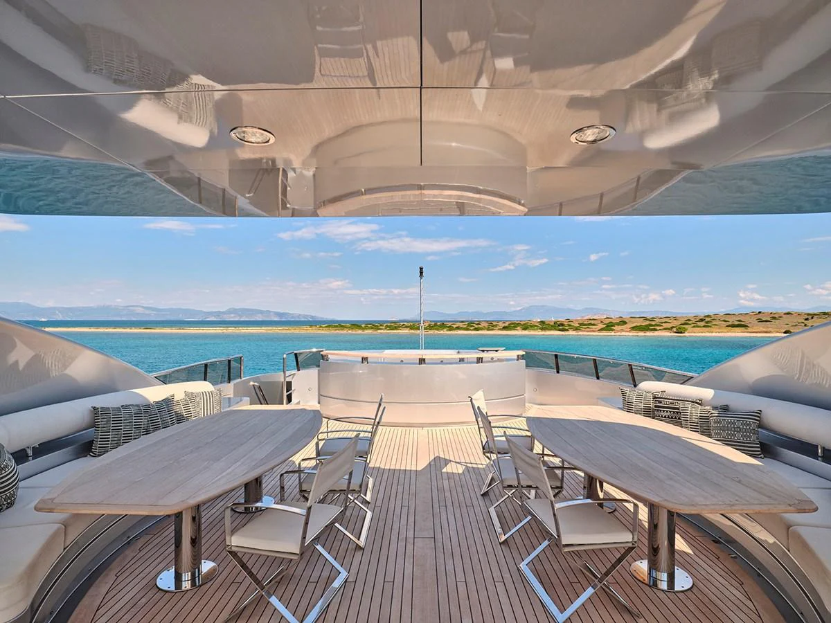 The aft deck offers a spacious and elegant outdoor dining area with stunning views of the sea. aboard BELITA Yacht for Sale