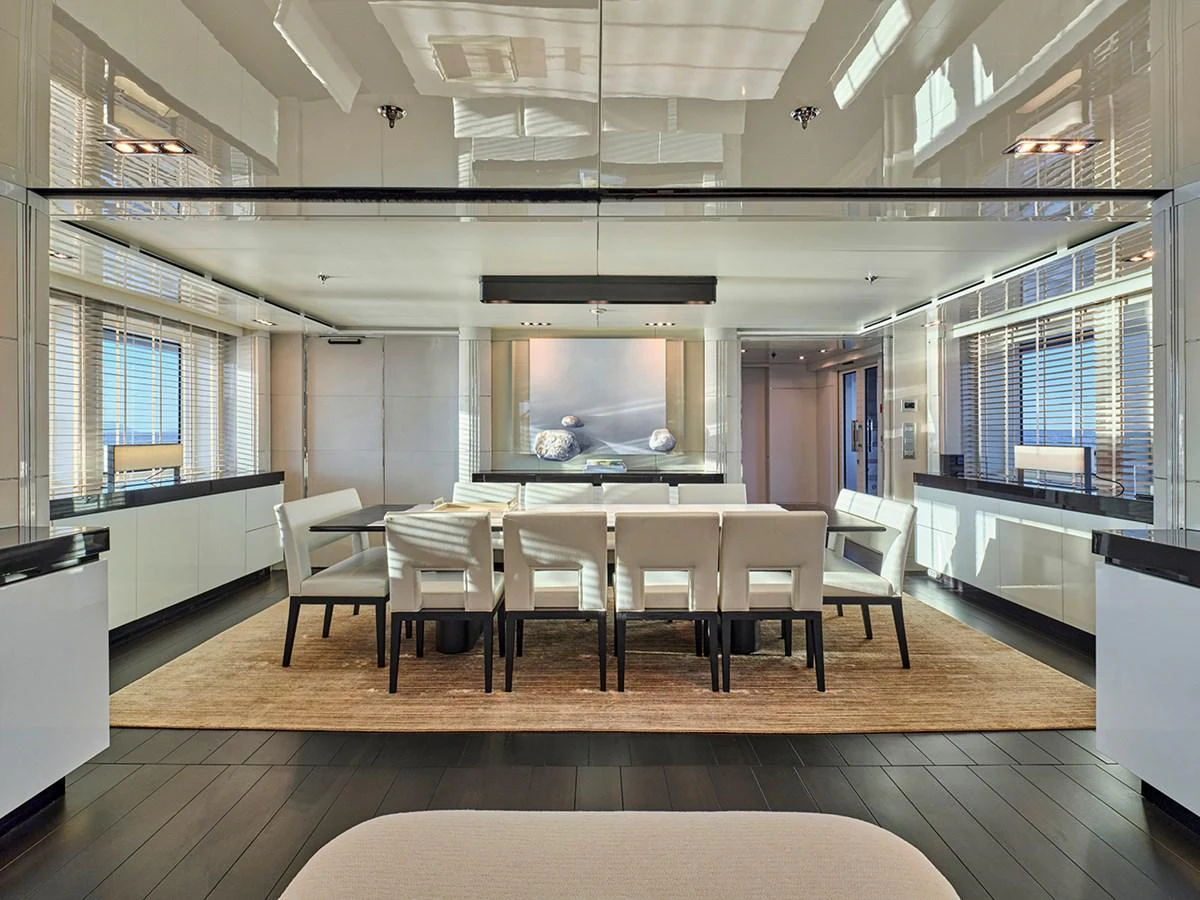 The dining area features a sleek, modern design with ample seating and large windows for natural light. aboard BELITA Yacht for Sale
