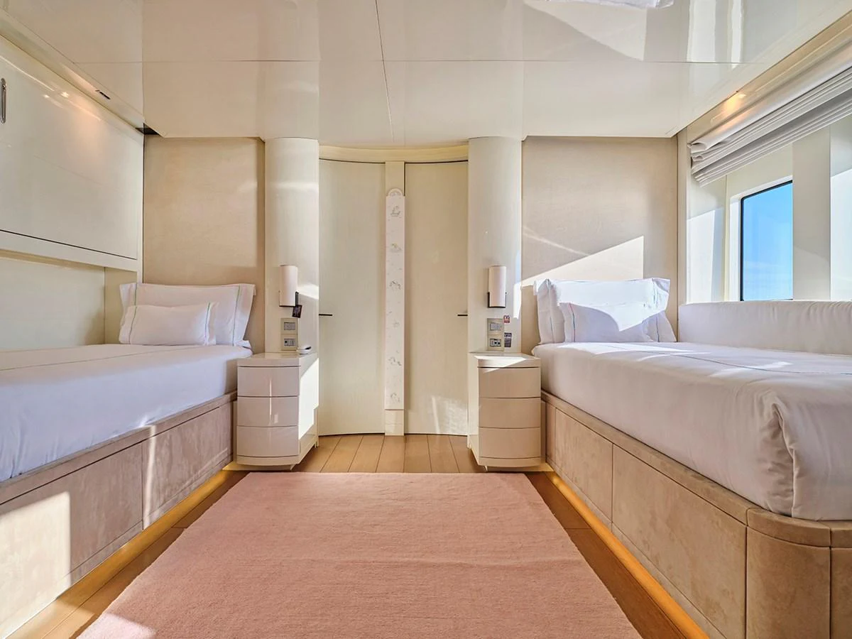 A luxurious twin stateroom with modern decor and ample natural light. aboard BELITA Yacht for Sale