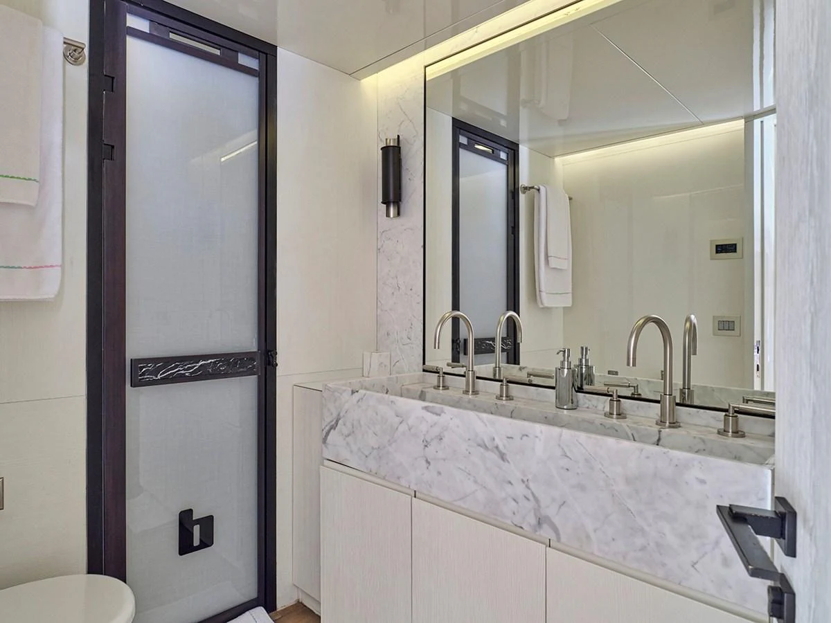 The yacht's bathroom features a sleek, modern design with a marble countertop and dual sinks. aboard BELITA Yacht for Sale